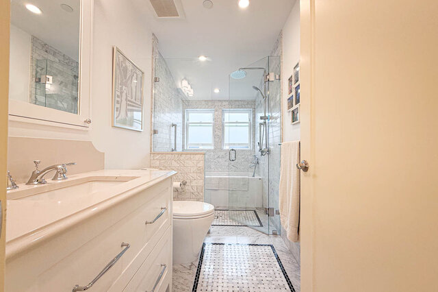 Spacious bathroom featuring a white vanity, glass-enclosed shower, and mosaic tile floor. - 3752 West 23rd Avenue, Vancouver West Side