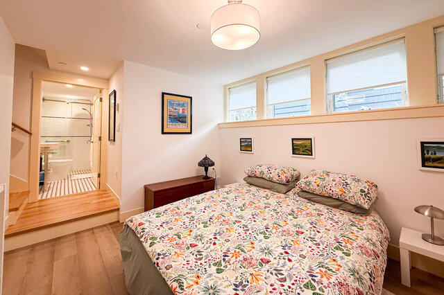 Furnished bedroom with floral bedding, hardwood floors, and skylight windows above the bed. - 3752 West 23rd Avenue, Vancouver West Side