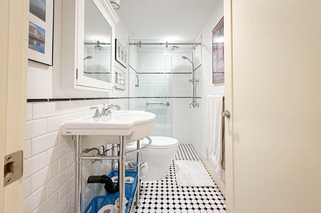 Bathroom with white subway tile, black-and-white checkered floor, and a glass-enclosed shower. - 3752 West 23rd Avenue, Vancouver West Side