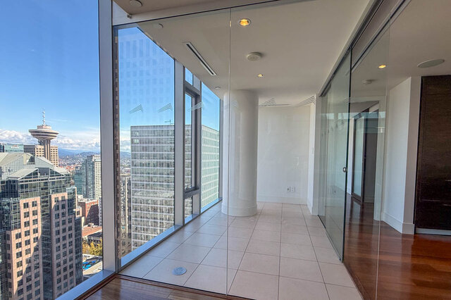 Glass-enclosed balcony with light tile flooring and a sweeping city view of the Vancouver skyline. - 2702-667 Howe Street, Vancouver Downtown