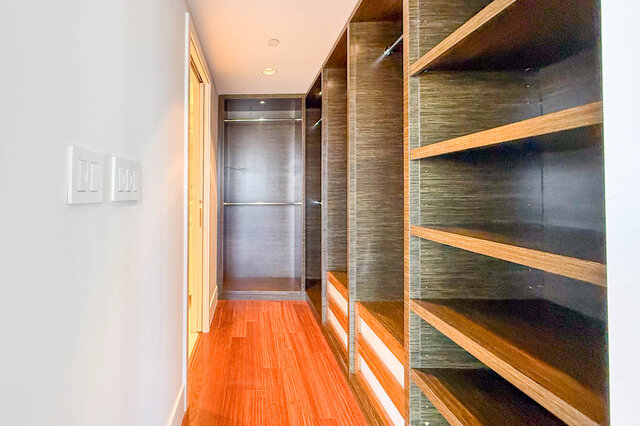 Walk-in closet with built-in wood shelving and warm hardwood floors. - 2702-667 Howe Street, Vancouver Downtown