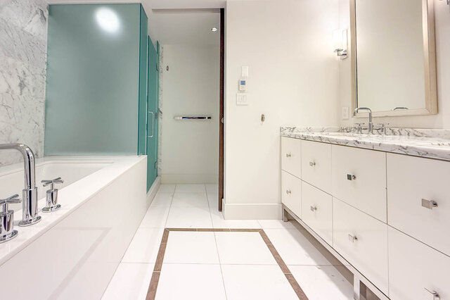 Spacious bathroom with white marble countertops, a built-in tub, and a frosted glass shower enclosure. - 2702-667 Howe Street, Vancouver Downtown