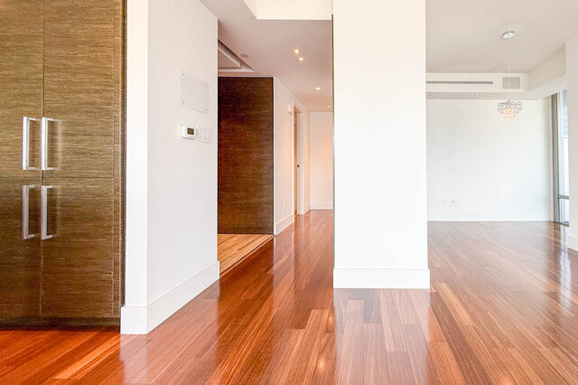 Bright entryway with glossy hardwood floors, white walls, and dark wood cabinetry. - 2702-667 Howe Street, Vancouver Downtown