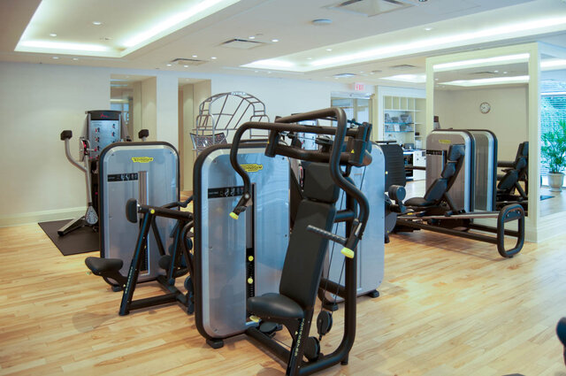 Fitness room with Technogym strength machines on light hardwood floors and a wall of mirrors. - 2702-667 Howe Street, Vancouver Downtown