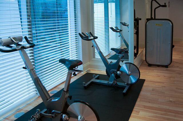 Home gym with two stationary bikes on hardwood floors and large windows with city views. - 2702-667 Howe Street, Vancouver Downtown