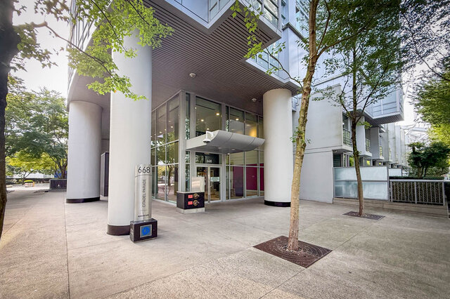 Covered condo entrance with white columns and a tree-lined paved plaza. - 1603-668 Citadel Parade, Vancouver Downtown