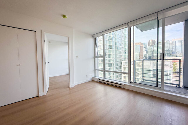 Living room with gray sofa and floor-to-ceiling windows overlooking the Vancouver downtown skyline. - 1603-668 Citadel Parade, Vancouver Downtown
