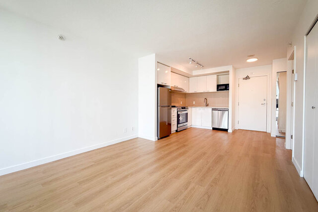 Furnished bedroom with a wood-headboard bed and floor-to-ceiling windows offering a high-rise city view. - 1603-668 Citadel Parade, Vancouver Downtown