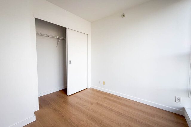 Compact kitchenette with white cabinets, stainless steel sink, dishwasher, and hardwood floors. - 1603-668 Citadel Parade, Vancouver Downtown