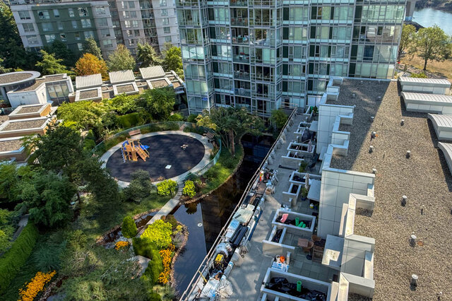 Rooftop amenity deck with gravel roof and skylights overlooking a landscaped courtyard and playground.