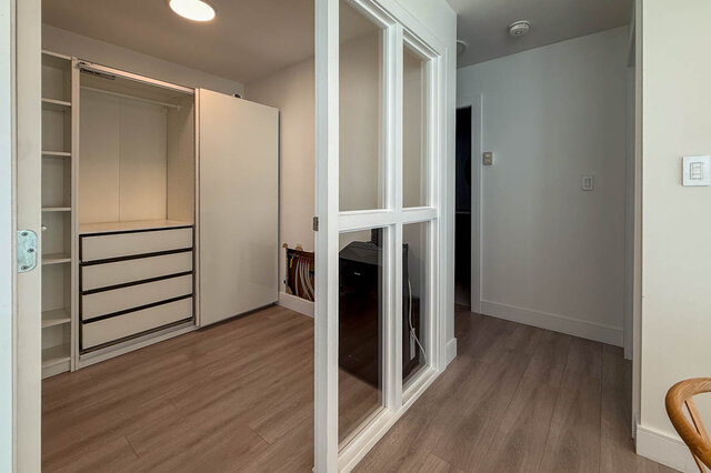 Hallway with built-in sliding-door closet, glass-paned partition, and light hardwood floors. - 1101-1067 Marinaside Crescent, Vancouver Downtown