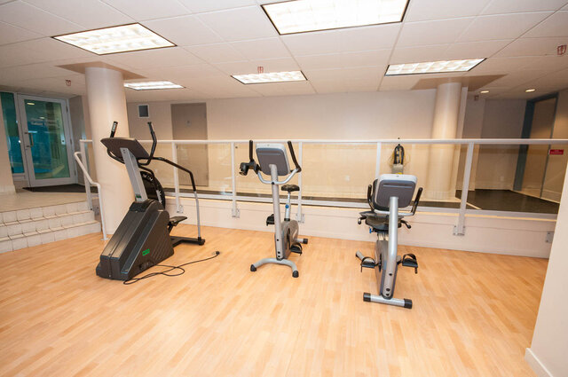 In-unit fitness room with light hardwood floors and a glass railing overlooking the lower level. - 1101-1067 Marinaside Crescent, Vancouver Downtown
