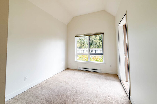 Bedroom with a vaulted ceiling, carpet and a large window onto trees. - 302-1533 East 8th Avenue, Vancouver East Side