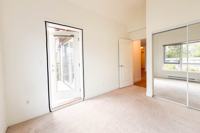 Bedroom with a mirrored sliding closet and a door out to its own balcony. - 302-1533 East 8th Avenue, Vancouver East Side