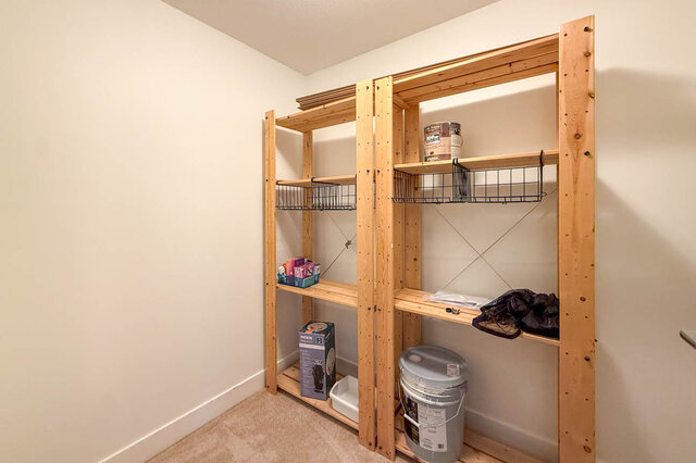 Den set up as in-suite storage with wood shelving units and carpet. - 302-1533 East 8th Avenue, Vancouver East Side