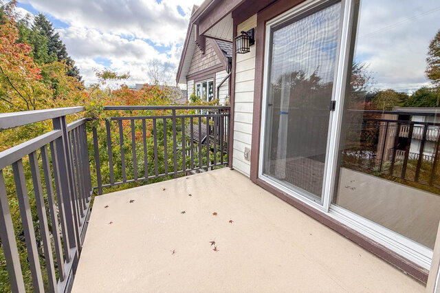 Bedroom balcony with a metal railing surrounded by red and green maple trees. - 302-1533 East 8th Avenue, Vancouver East Side