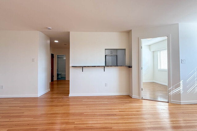 The living room wall with the kitchen pass-through counter, the hall to the bathroom and a bedroom door - 107-461-16th Street West, North Vancouver