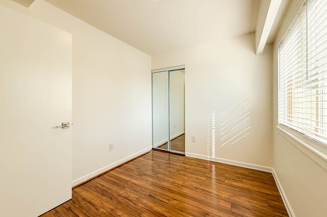 The second bedroom with its mirrored closet and window - 107-461-16th Street West, North Vancouver