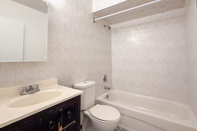 The four-piece bathroom with a tub and shower, tile walls and a vanity - 107-461-16th Street West, North Vancouver