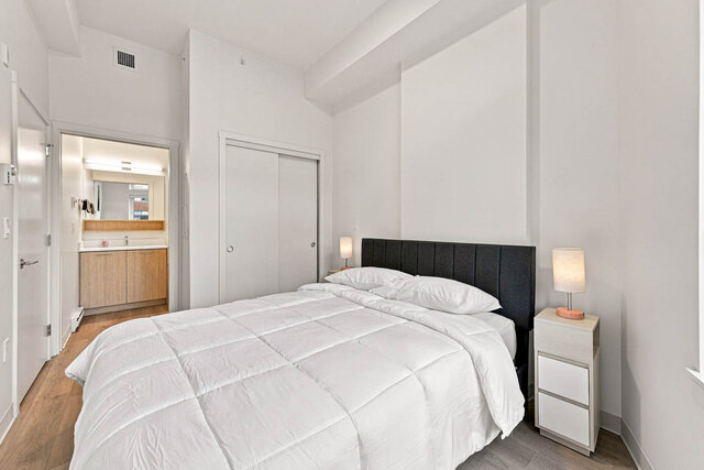 Primary bedroom with the queen bed, a sliding closet and a door through to its bathroom. - 111-1529 Oxford Street, North Vancouver