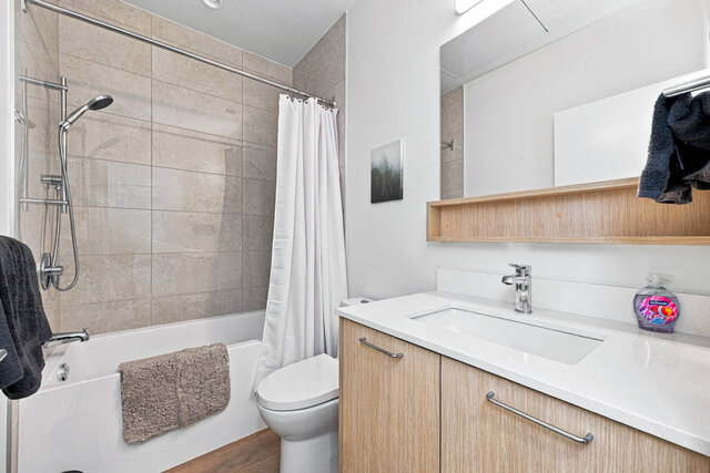 Second full bathroom with a tub and shower, tile surround and a light wood vanity. - 111-1529 Oxford Street, North Vancouver