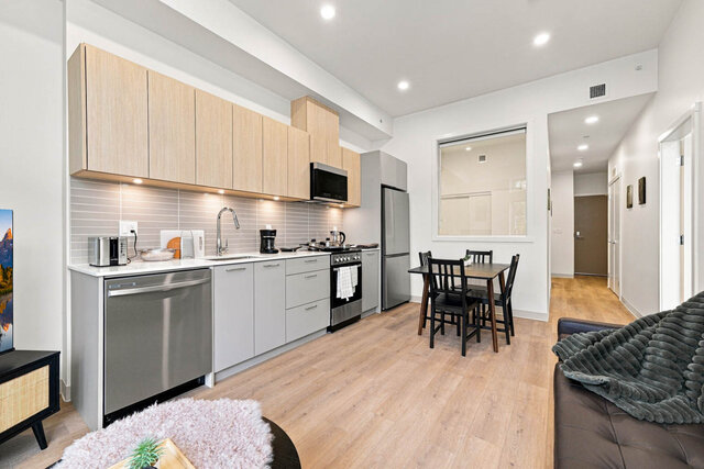 Kitchen and dining table, with the hall leading back to the entry door. - 111-1529 Oxford Street, North Vancouver