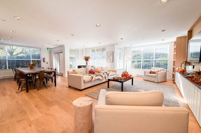 Shared resident lounge with a long dining table, sofas, a coffee table and big windows on two sides. - 402-3205 Mountain Highway, North Vancouver