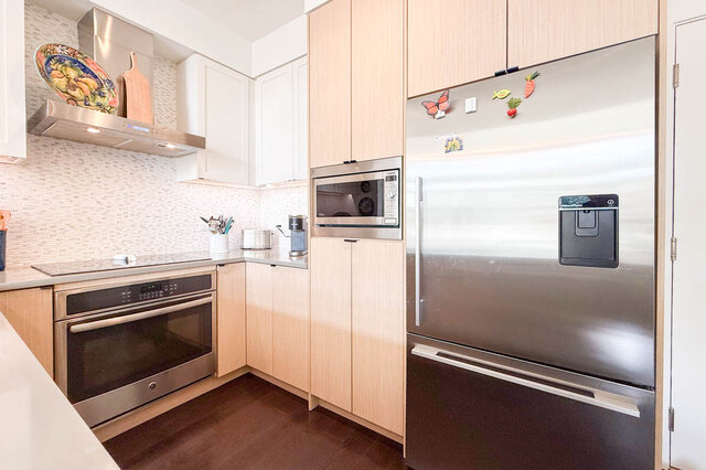 Stainless fridge, built-in microwave, wall oven and cooktop under light wood cabinets. - 402-3205 Mountain Highway, North Vancouver