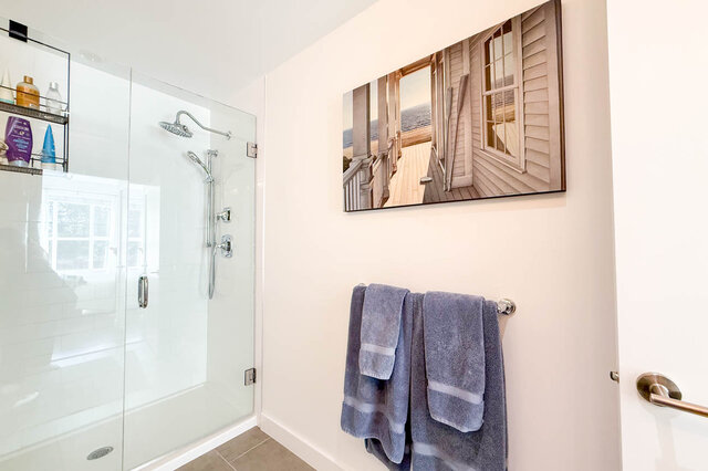 Walk-in glass shower with a rain shower head and a hand shower in the ensuite. - 402-3205 Mountain Highway, North Vancouver