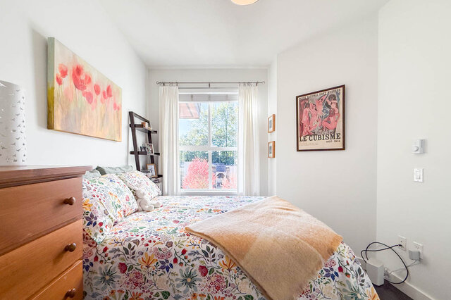 Second bedroom with the double bed facing a window with trees outside. - 402-3205 Mountain Highway, North Vancouver