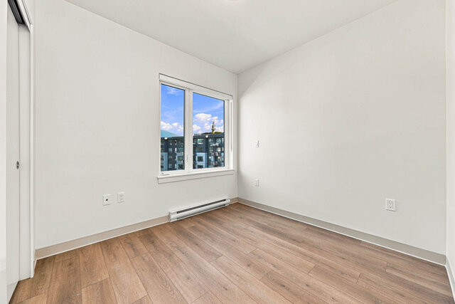 Second bedroom with a large window, a sliding closet and hardwood floors. - 525-1529 Oxford Street, North Vancouver
