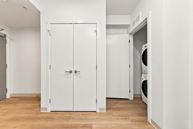 Stacked washer and dryer in a closet by the entry, next to a double-door hall closet. - 525-1529 Oxford Street, North Vancouver