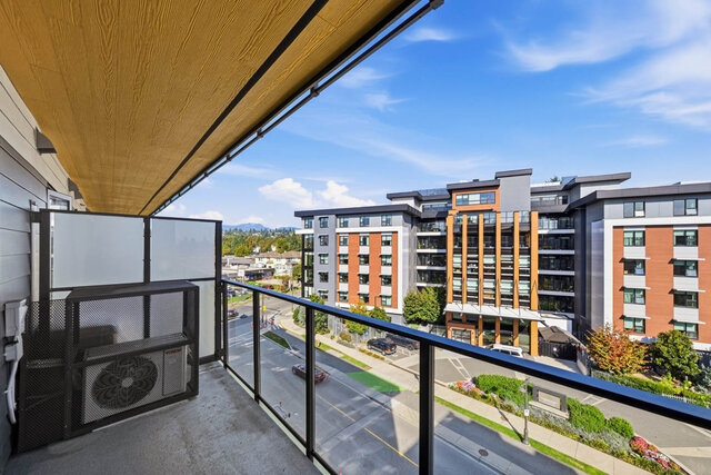 Covered balcony with a glass railing over Oxford Street, the neighbouring buildings and distant mountains beyond.
