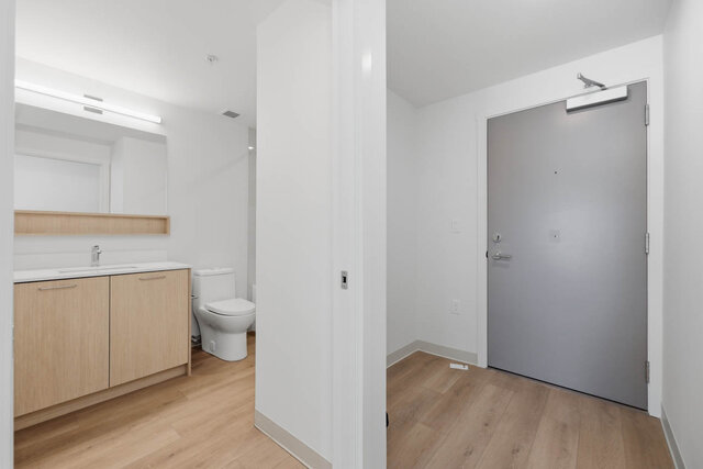 Main bathroom with a light wood vanity beside the grey front entry door. - 619-1529 Oxford Street, North Vancouver