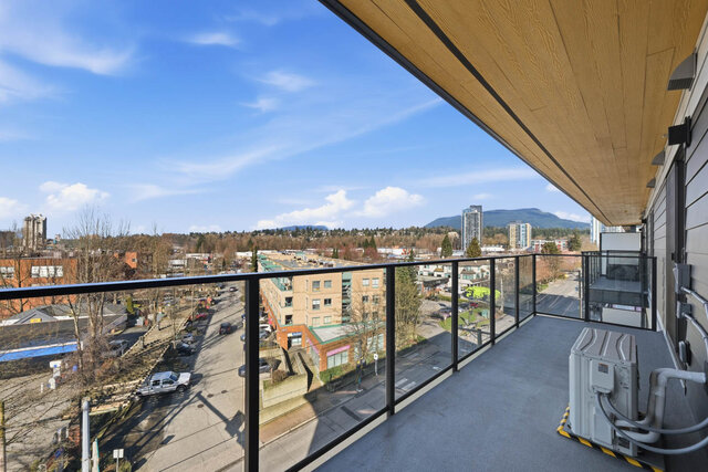 Long covered balcony with a glass railing, looking over the street to the North Shore mountains. - 619-1529 Oxford Street, North Vancouver