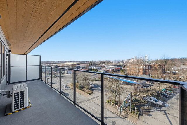 Covered balcony with a glass railing and privacy screen, the downtown skyline in the distance. - 619-1529 Oxford Street, North Vancouver