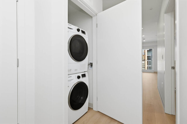 Stacked washer and dryer in a closet off the hall, with the hall running toward the living room. - 424-1529 Oxford Street, North Vancouver