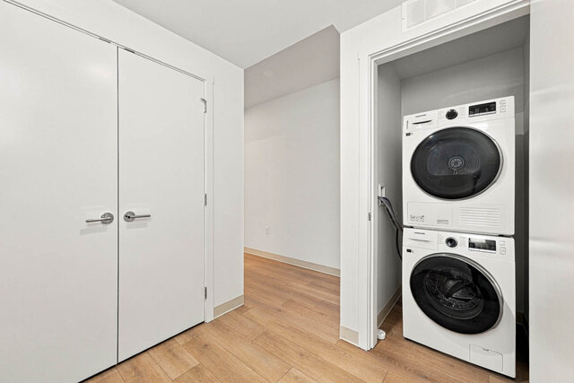 Hall with a double-door closet and a stacked washer and dryer in its own closet. - 405-1529 Oxford Street, North Vancouver