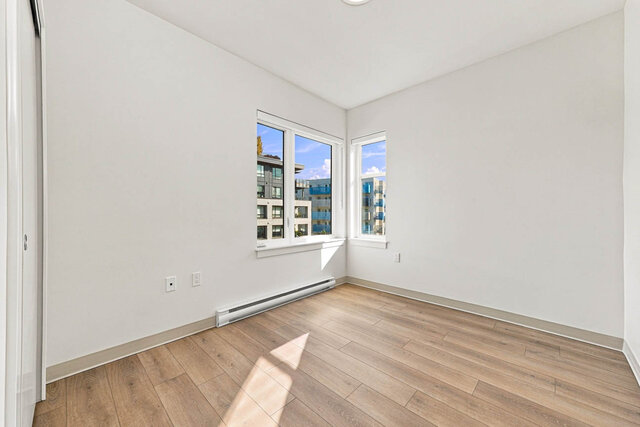 Empty corner second bedroom with windows on two walls and a sliding closet. - 405-1529 Oxford Street, North Vancouver