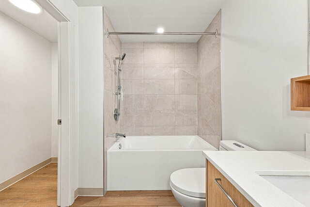 Tub and shower with a handheld shower head and tile surround. - 409-1529 Oxford Street, North Vancouver