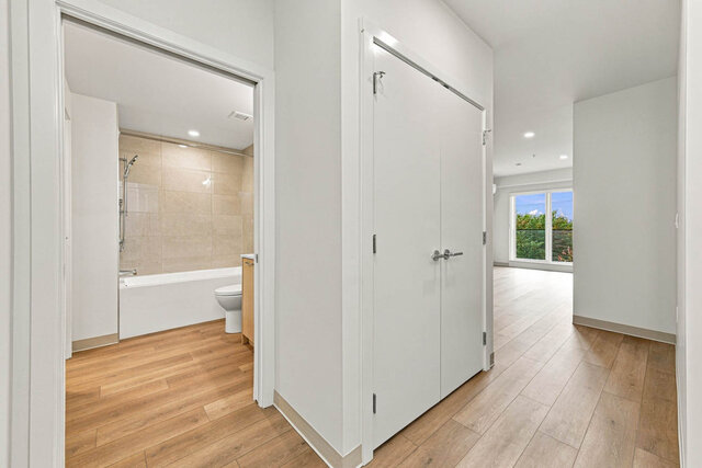 Hallway past a bathroom and a double closet, leading to the bright living room. - 409-1529 Oxford Street, North Vancouver