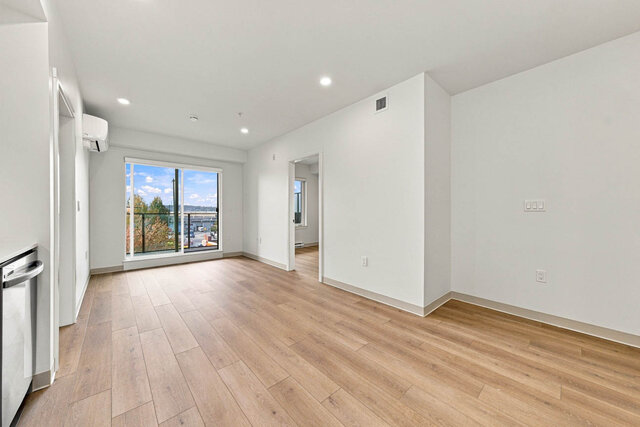 Living area with a sliding door to the balcony, an air conditioner and a bedroom door off one side. - 409-1529 Oxford Street, North Vancouver