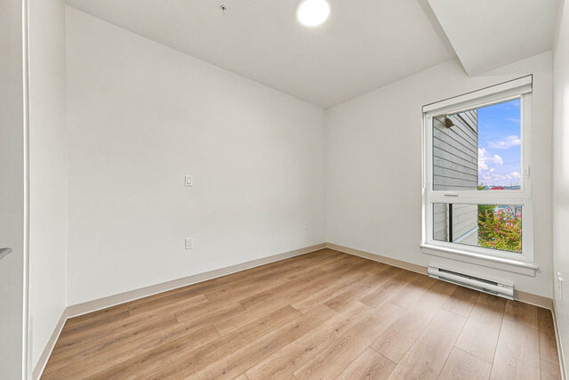 Bedroom with a tall window and a ceiling light. - 409-1529 Oxford Street, North Vancouver