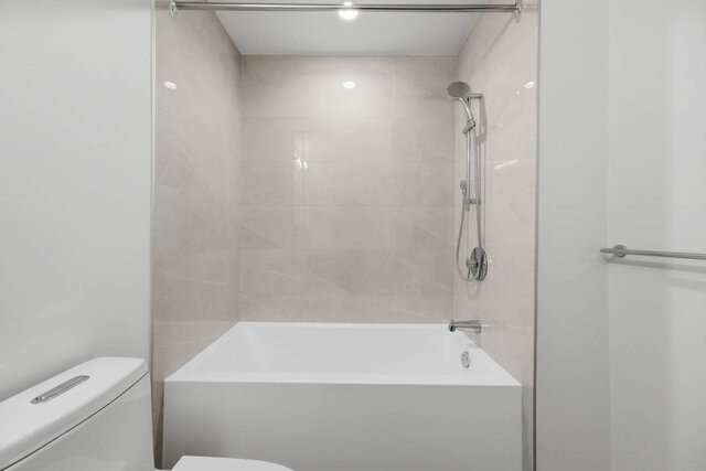 Tub and shower with a handheld shower head and tile surround. - 518-1529 Oxford Street, North Vancouver