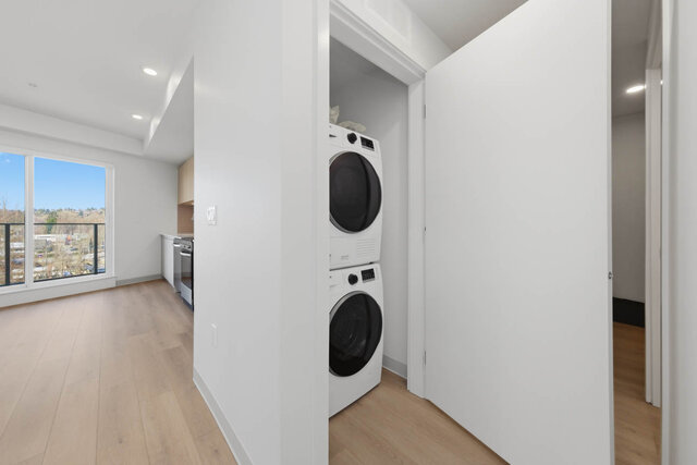 Stacked washer and dryer in their own closet, with the kitchen and living area beside it. - 518-1529 Oxford Street, North Vancouver