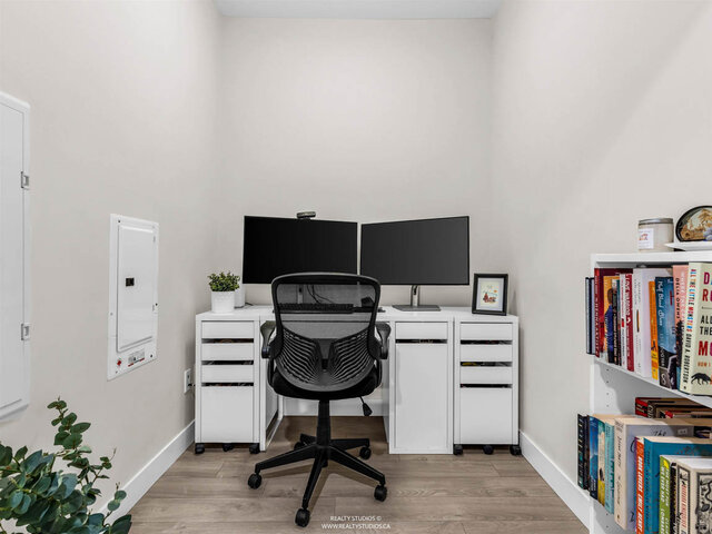 Den set up as a home office with a desk, two monitors and a bookshelf. - 117-723 3rd street West, North Vancouver
