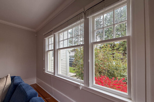 Bank of tall windows in the living room looking onto the garden. - North Vancouver