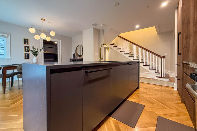 Waterfall island with a brass faucet, looking to the staircase and the dining area. - North Vancouver