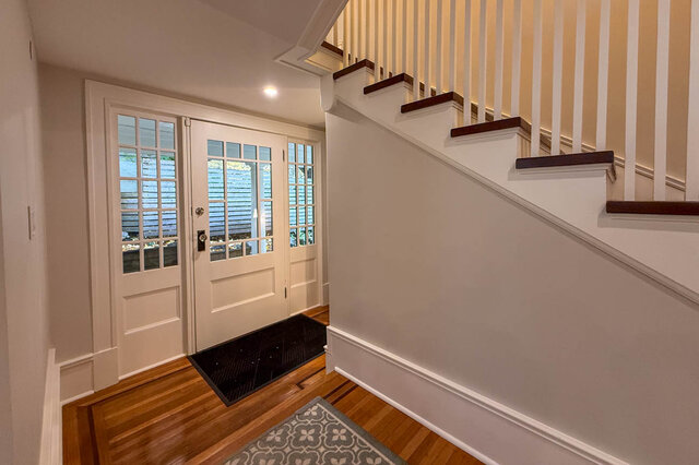 Side entry inside, with glass-paned doors beside the staircase. - North Vancouver