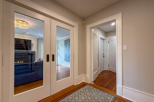 Glass pocket doors to the living room, beside the hall to the powder room. - North Vancouver